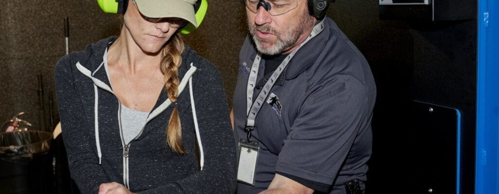 The Most Important Safety Device Is Between Your Ears 3 A man helping a woman train in gun use.