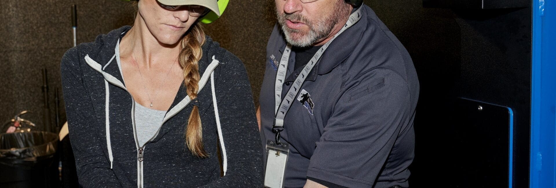 The Most Important Safety Device Is Between Your Ears 2 A man helping a woman train in gun use.